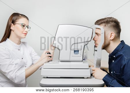 Attractive Dark-haired Young Woman Doctor Measures Eye Pressure On Ophthalmic Equipment To Fashionab