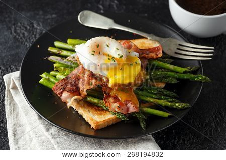 Benedict Poached Duck Egg With Crispy Bacon And Fried Asparagus On Toasts For Breakfast