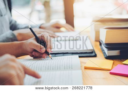 High School Or College Students Studying And Reading Together In Library