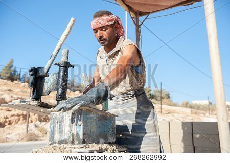 Man making brick from concrete mix.Zarqa-Jordan. 22/7/2013