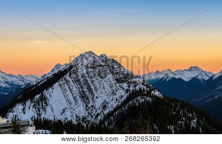 Stunning Sunset Skyline Of Snow Capped Canadian Rocky Mountains At Banff National Park In Alberta, C