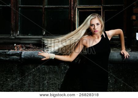 Portrét blondýna s rozcuchanými vlasy, v pozadí město