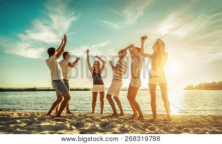 Happiness Friends funny dance on the beach under sunset sunlight in summer sunny day.