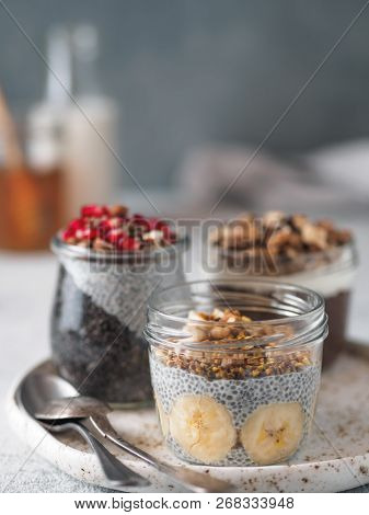 Set Of Chia Pudding In Different Glass Jars On Table. Assortment Of Chia Puding With Different Fruit