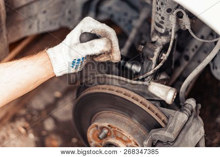 A Closeup Of The Work On Unscrewing The Car Shock Absorber Mounting Nuts.