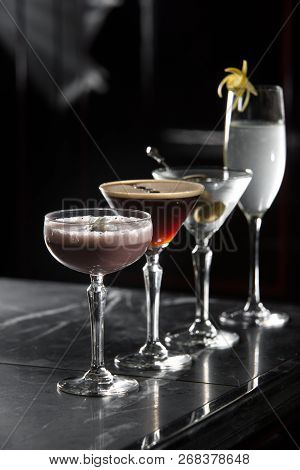 Four Special Cocktails On A Bar Desk. Black Background