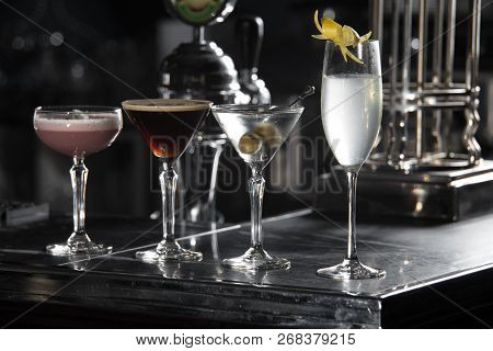 Four Special Cocktails On A Bar Desk. Black Background
