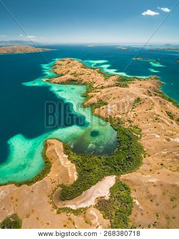 Bays, savanna lands, ocean. Komodo. Aerial view. Spectacular panorama above the stunning bays and savanna territory of Komodo National Park. Indonesia. Heritage Site. Overview drone shot.