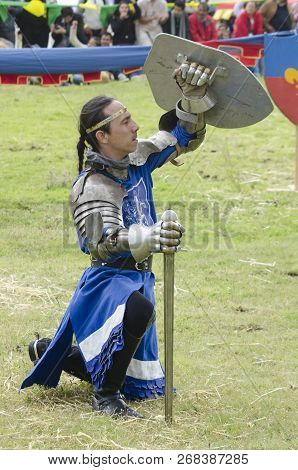 Tlaxcala, Mexico- September 29, 2018: Knight Kneeled Down Sticking A Sword On The Grass And Lifting 