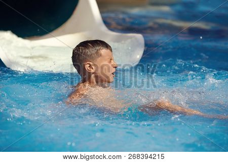Boy Havimg Fun At Waterpark.  He Just Dived In Waterpark Pool After From Sliding Flume.