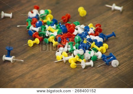 Colored Pins To Hold Notes On Wooden Background