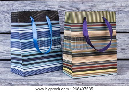 Two Striped Shopping Bags On Wooden Background. Two Paper Bags With Colorful Stripes, Horizontal Ima