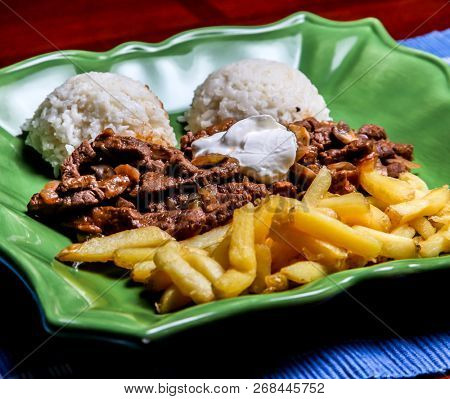 Sote stroganoff with rice and french fries on plate