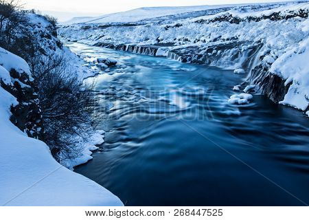 Hraunfossar waterfall in winter, long exposure. One of the most popular waterfall in Iceland, Europe.