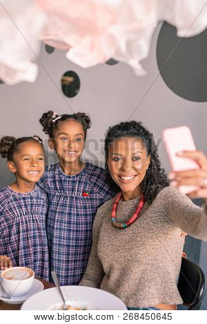 Stylish Woman Holding Phone Making Selfie With Cute Daughters