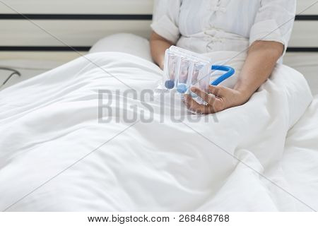 Elderly Patient Using Incentive Spirometer Or Three Balls For Stimulate Lungs In Bedroom