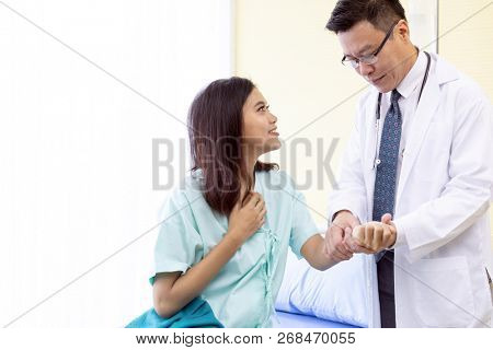 Asian Doctor make routine health check with patient in hospital ward