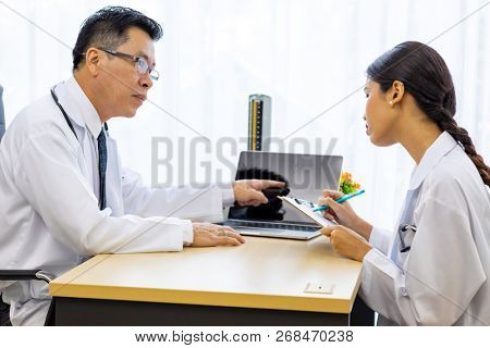 Two doctors in the hospital discuss the diagnos of the patient