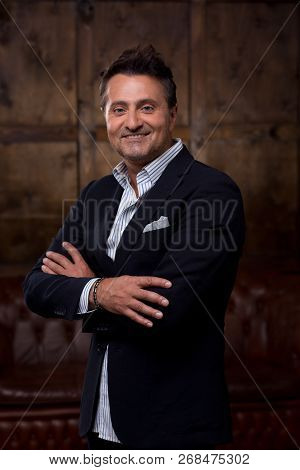 Confident Middle Aged Businessman Wearing Stylish Clothes And Smiling While Standing With His Arms C