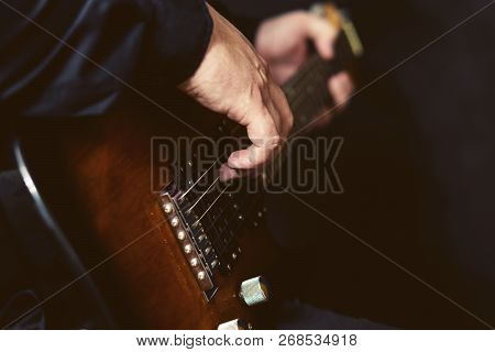 Close-up Fingers Of The Musician Touch The Strings Of A Six-string Electric Guitar.