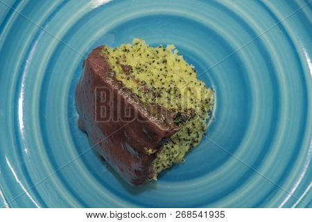 Marijuana Poppy Seed Cake With Chocolate And Fruit Glaze On Blue Plate