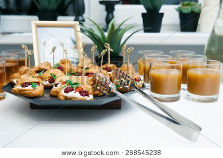 Sweet Catering With Berry Cackes And Juice At White Table