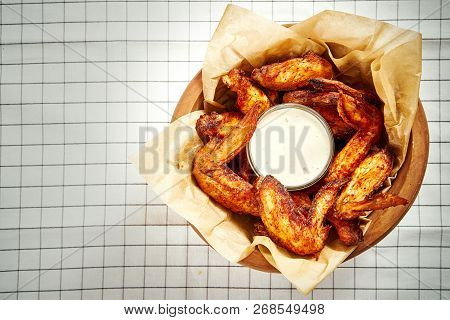 Top View Of Delicious Fried Chicken Wings In A Bowl, Fries On A Checkered Tablecloth