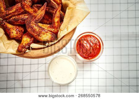 Top View Of Delicious Fried Chicken Wings In A Bowl On A Checkered Tablecloth