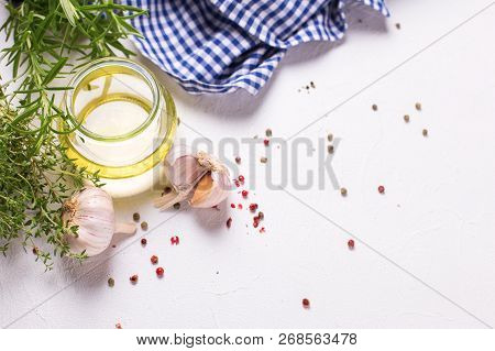 Bottle With Olive Oil With Herb And Spices On  White Textured Background. Top View. Selective Focus.