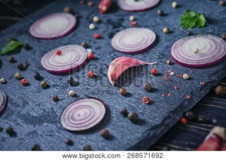 Onions, Garlic, Pepper Peas And Greens On A Gray Board