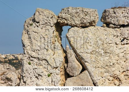 View Of Big Church Dome Through Hole In Giant Ancient Stones Ggantija Temples On Gozo Island, Malta 