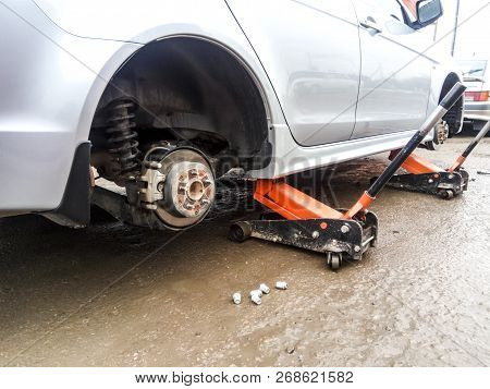 The Car Is At The Tire Shop. Under The Jack The Car In Car-care Center. The Car With The Removed Whe