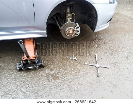 The Car Is At The Tire Shop. Under The Jack The Car In Car-care Center. The Car With The Removed Whe