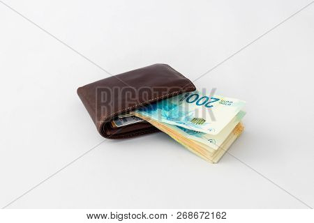 Вrown  Leather Wallet And Stack Of Banknotes New Israeli Shekels Isolated On White Background
