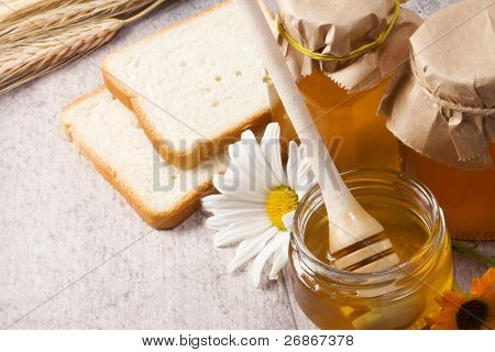 miele, fiori, spike e pane sul tavolo