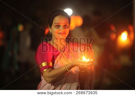 Pune, India - November 2018: A Woman Lights Up A Lamp During A Public Celebration Of Diwali Festival