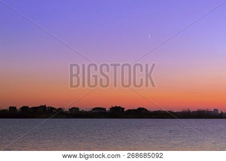 Amazingly Beautiful Sunset In Golden Pink Tones On The Background Of Small Houses On The Riverbank A