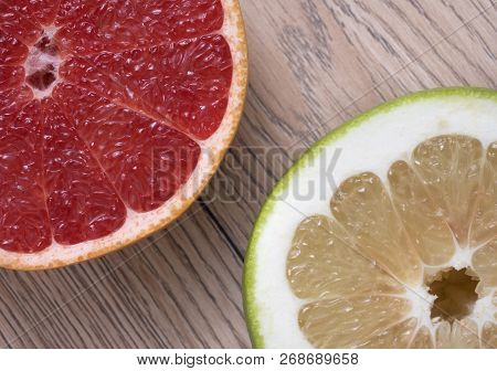 Green Sweetie Or Pomelit And Red Grapefruit On Wooden Background. Top View.