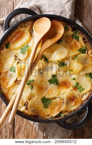 Janssonin Kiusaus Baked Potato With Anchovy Fillets, Onions And Heavy Cream Close-up In A Frying Pan