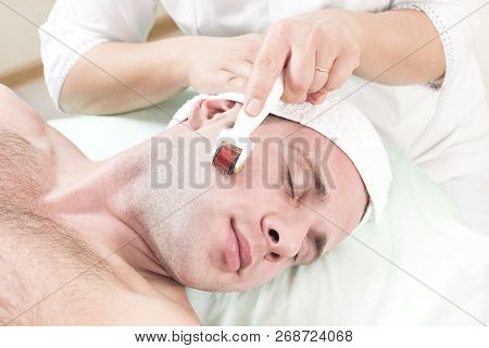 The Man Undergoes The Procedure Of Medical Micro Needle Therapy With A Modern Medical Instrument Der