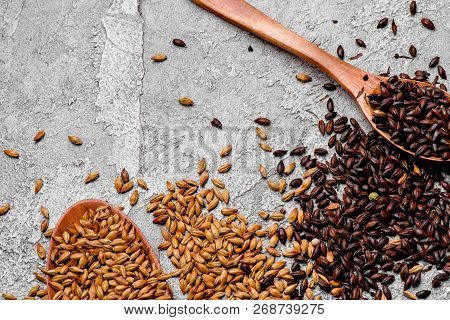 malted grains in a wooden spoon closeup. Mixed varieties of malted grain on a gray background. close-up. top view. flat lay. series of photos. space
