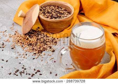 Malt grain and a glass of beer. Mixed varieties of malted grain on a gray background. close-up. top view. flat lay. series of photos. space