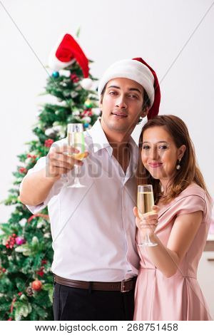 Young couple celebraring christmas with champagne
