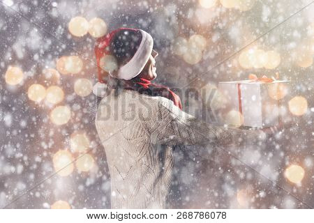 Christmas Gift Concept. Man In Santa Hat Bring Gift For You. Attractive Man Hold Box.  Christmas And