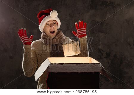 Christmas Gift Concept. Man In Santa Hat Bring Gift For You. Attractive Man Hold Box.  Christmas And