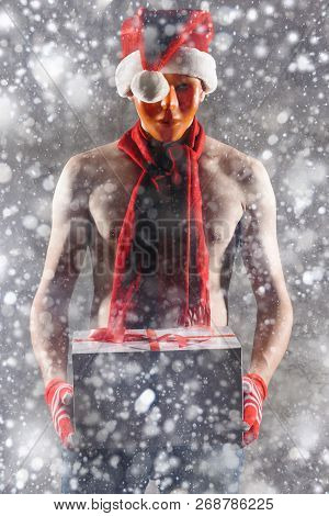Christmas Gift Concept. Man In Santa Hat Bring Gift For You. Attractive Man Hold Box.  Christmas And