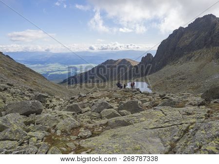 Nizne Wahlenbergovo Pleso Mountain Lake In Furkotska Dolina Valley With Group Of Resting Hikers View