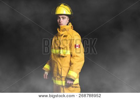 Portrait Of The Fireman Standing Waist Up Studio Shot On Black Background And Moke.