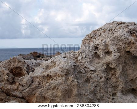 Rugged Rocks Against A Deep Blue Sea With Bright Sky With White Clouds In Menorca Spain Travel Or Va