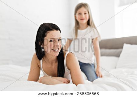 Mother And Daughter Enjoy In Bed At Home